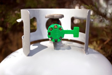 white propane tank with green nozzle